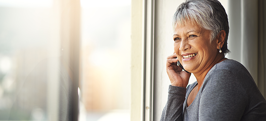 Lady in gray shirt smiling while on the phone