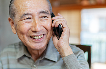 A smiling man using his cellphone